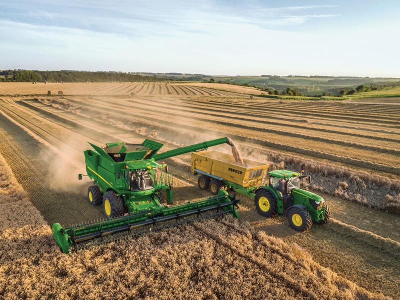 La John Deere série S peut  prendre le contrôle de la direction  du tracteur pour automatiser la vidange de la trémie en marche.