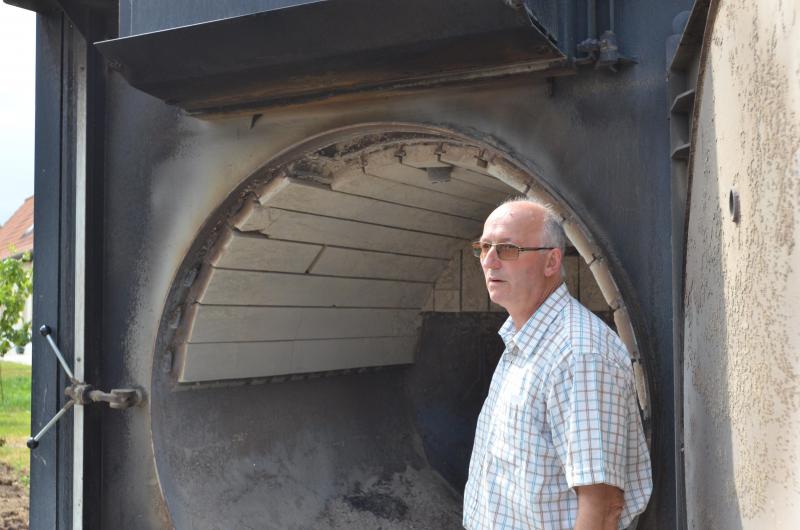 Jean-Bernard Ronckier devant la chaudière à Biomasse qui lui permet d’être autonome en énergie mais également en eau chaude pour le besoin de ses installations.