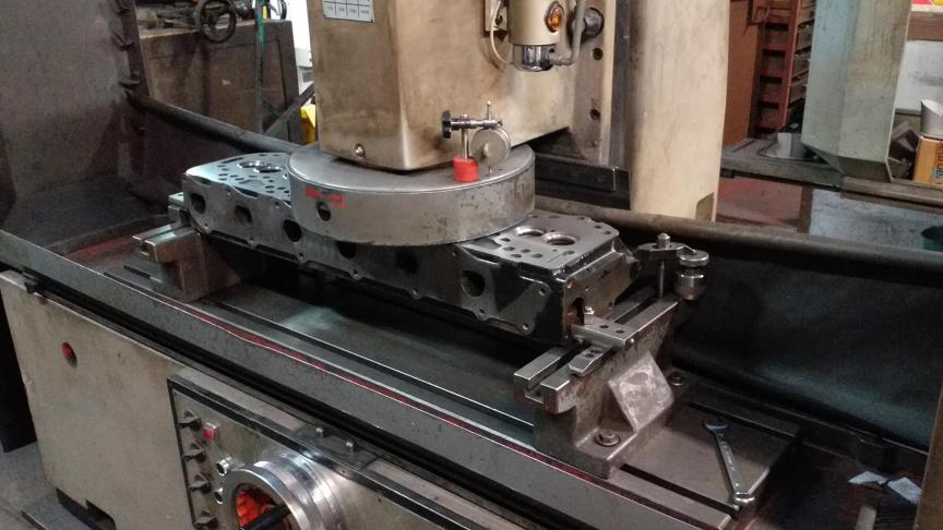 Cette culasse d’un moteur de tracteur à 6 cylindres est en cours de rectification pour lui rendre une surface parfaitement plane.